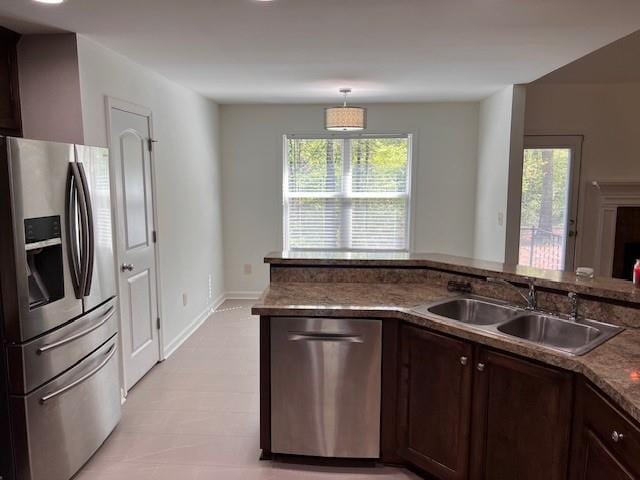 kitchen with hanging light fixtures, dark brown cabinetry, sink, and stainless steel appliances