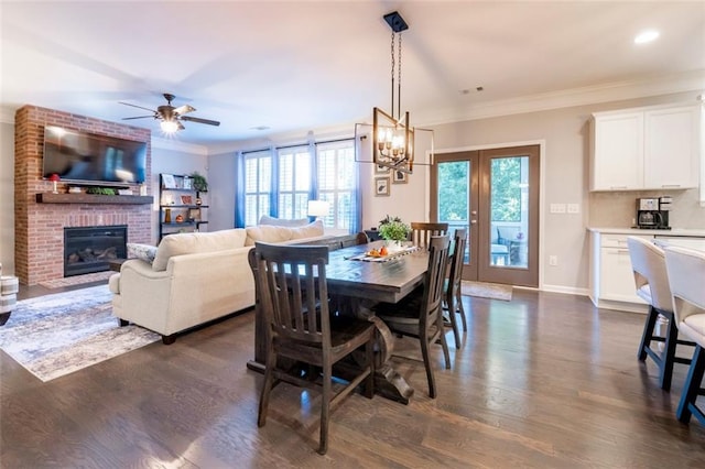 dining room featuring ornamental molding, plenty of natural light, a fireplace, and french doors