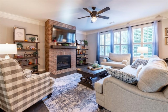 living room featuring hardwood / wood-style floors, crown molding, a brick fireplace, and ceiling fan