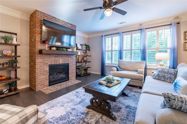 living room with crown molding, a fireplace, plenty of natural light, and dark hardwood / wood-style flooring