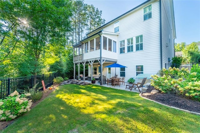 back of property featuring a sunroom, a lawn, and a patio area