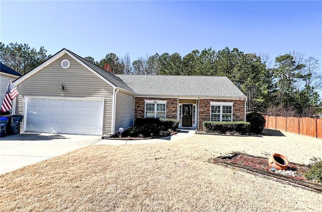 ranch-style house featuring fence, a garage, and driveway