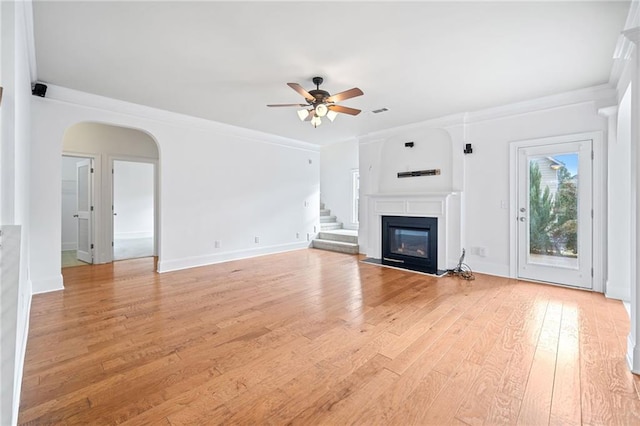 unfurnished living room featuring light hardwood / wood-style flooring, ceiling fan, and crown molding