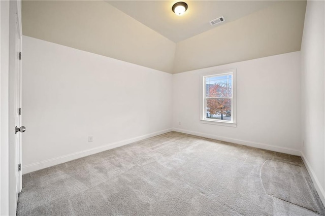 carpeted spare room with lofted ceiling