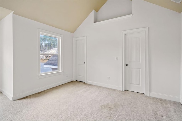 spare room with light colored carpet and high vaulted ceiling