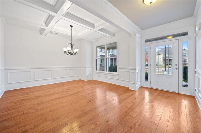 entryway with beam ceiling, coffered ceiling, a chandelier, wood-type flooring, and ornamental molding