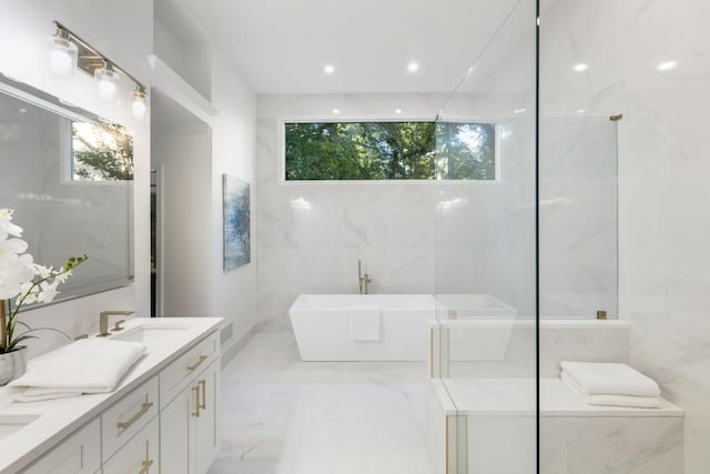 bathroom featuring vanity, a tub, tile walls, and plenty of natural light