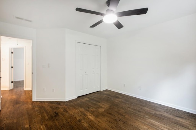 unfurnished bedroom with a closet, dark wood-type flooring, and ceiling fan