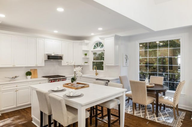 kitchen featuring dark wood-type flooring, stainless steel appliances, and white cabinets