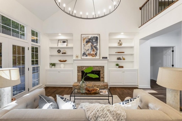 living room with high vaulted ceiling, a stone fireplace, dark hardwood / wood-style floors, and built in features