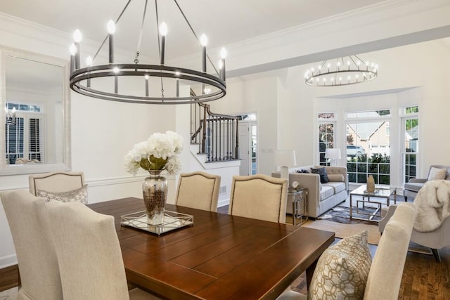 dining space with ornamental molding, a chandelier, and wood-type flooring