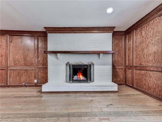 details featuring hardwood / wood-style floors, a brick fireplace, and wooden walls