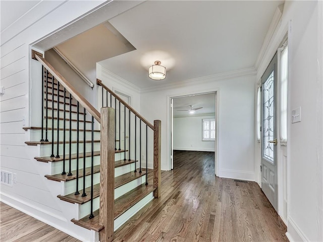 entrance foyer with hardwood / wood-style floors and crown molding