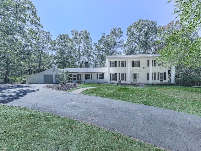 neoclassical home with a garage and a front lawn