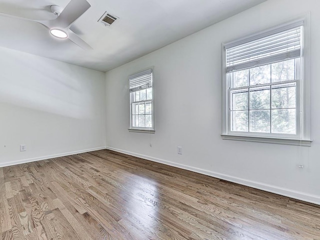 unfurnished room featuring hardwood / wood-style flooring, plenty of natural light, and ceiling fan