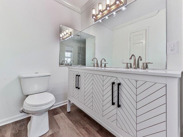 bathroom featuring vanity, hardwood / wood-style flooring, toilet, and ornamental molding