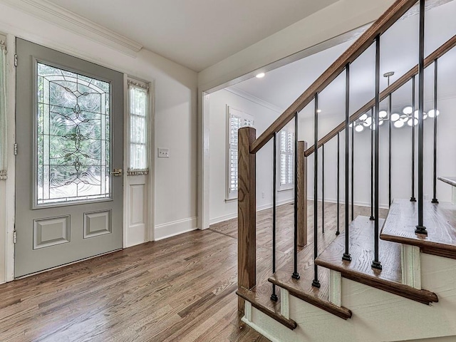 entrance foyer with ornamental molding and hardwood / wood-style flooring