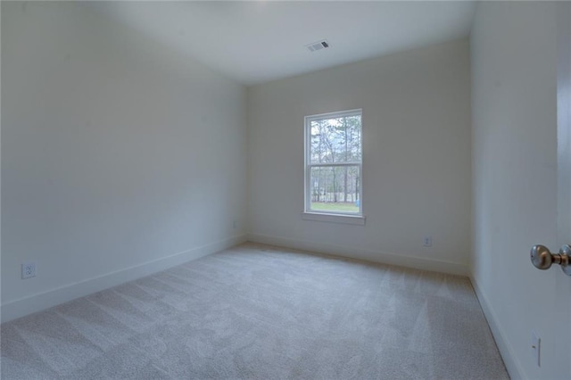 spare room with baseboards, visible vents, and light colored carpet