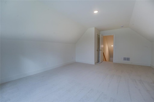 bonus room featuring light colored carpet, lofted ceiling, visible vents, and baseboards