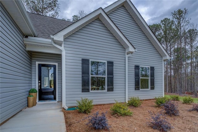 exterior space featuring roof with shingles