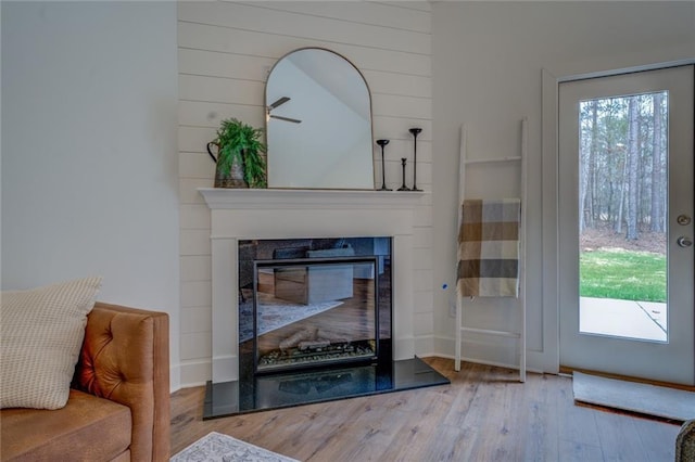 interior space featuring wood finished floors and a glass covered fireplace