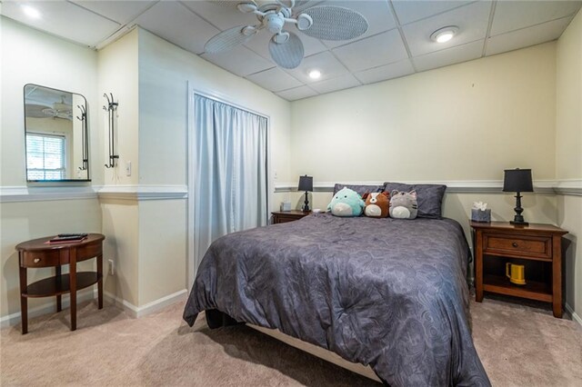 carpeted bedroom featuring a drop ceiling and ceiling fan