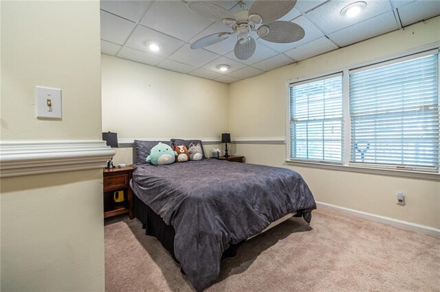 carpeted bedroom with ceiling fan and a paneled ceiling