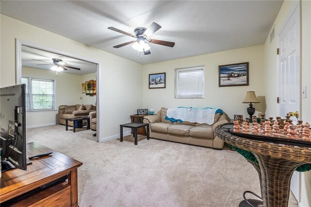 living room featuring ceiling fan and light colored carpet