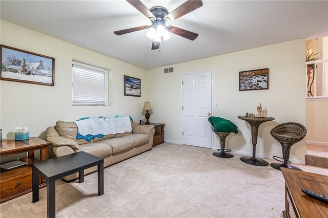 carpeted living room with ceiling fan