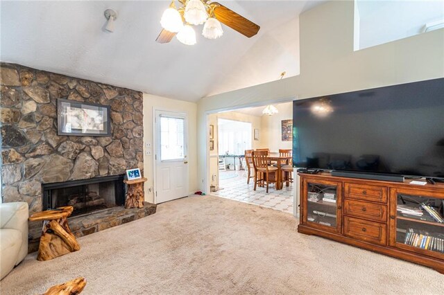 living room with a fireplace, light carpet, ceiling fan, and high vaulted ceiling