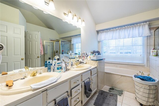 bathroom with independent shower and bath, vanity, lofted ceiling, and tile patterned floors