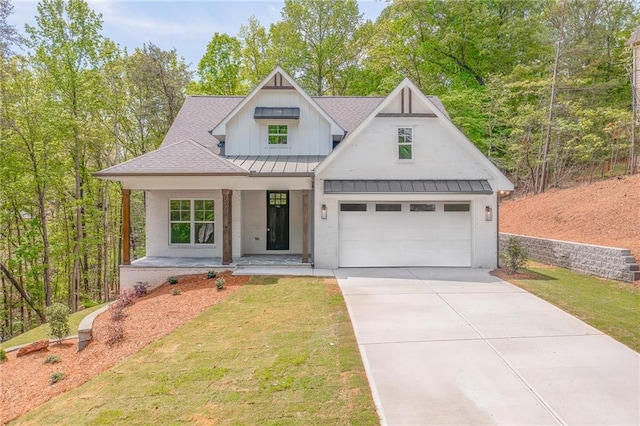 modern farmhouse with a front lawn, a standing seam roof, a shingled roof, a porch, and driveway