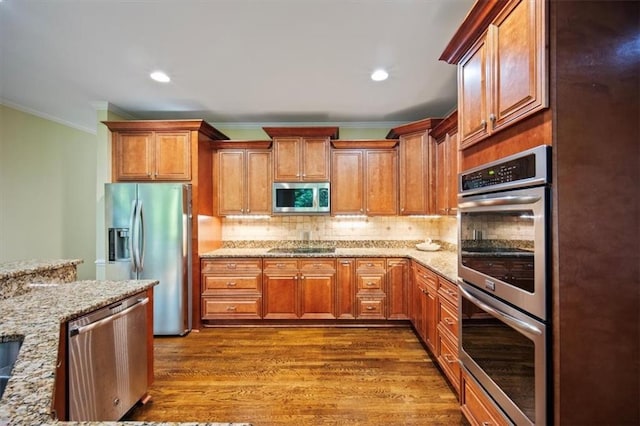 385 Guildhall Grv, Johns Creek, GA 30022 - kitchen with stainless steel appliances, crown molding, light stone countertops, decorative backsplash, and dark wood-type flooring