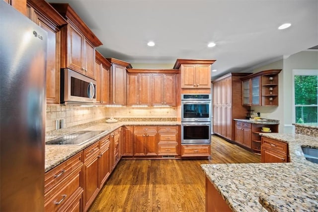 385 Guildhall Grv, Johns Creek, GA 30022 - kitchen with appliances with stainless steel finishes, dark wood finished floors, light stone counters, decorative backsplash, and ornamental molding