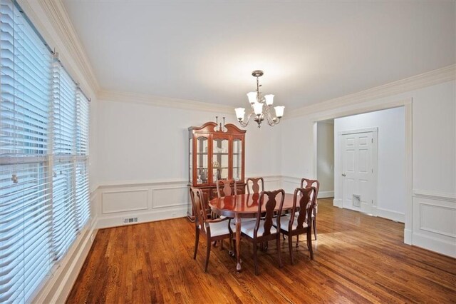 385 Guildhall Grv, Johns Creek, GA 30022 - dining area featuring a chandelier, wood finished floors, ornamental molding, a wainscoted wall, and a decorative wall