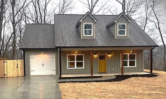 cape cod home with a garage and a porch