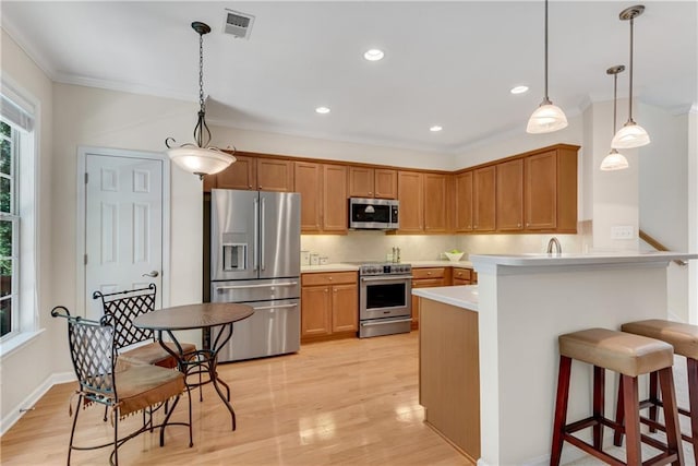 3733 Chattahoochee Summit Dr SE Unit 7, Atlanta, GA 30339 - kitchen featuring appliances with stainless steel finishes, ornamental molding, a peninsula, a breakfast bar area, and light countertops