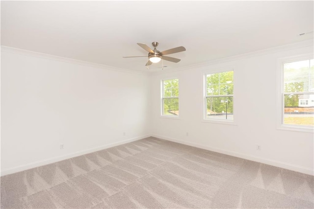 spare room with light carpet, ceiling fan, and crown molding