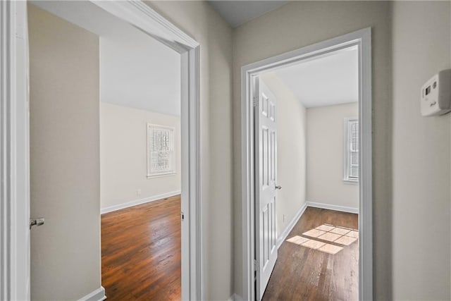 hallway with dark wood-style floors and baseboards