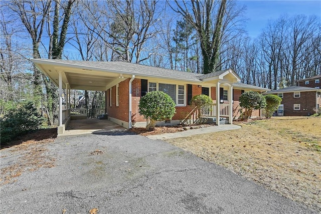 ranch-style home with a carport, brick siding, and driveway