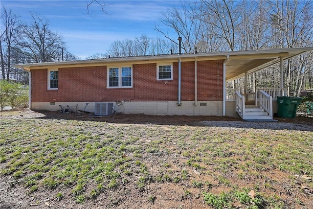 exterior space with central AC, brick siding, crawl space, and a lawn