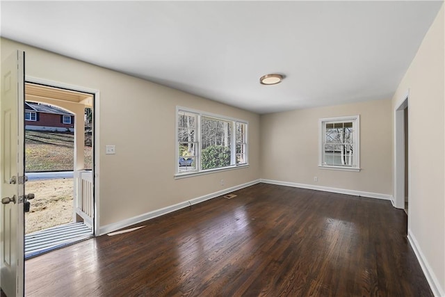 empty room with dark wood-style floors, french doors, and baseboards