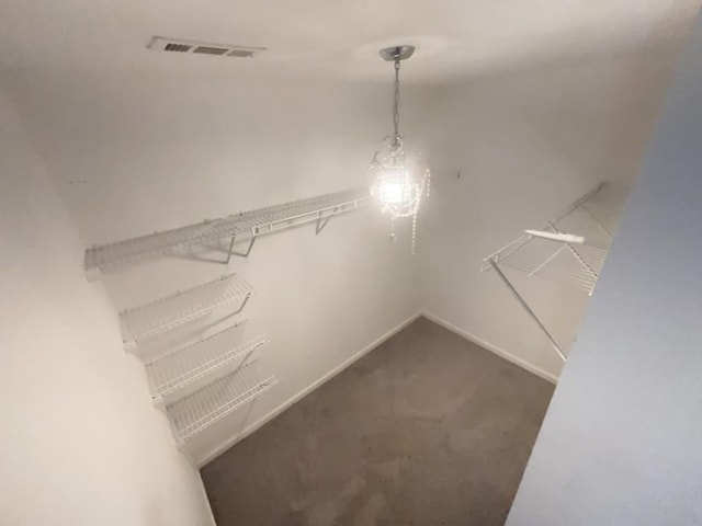 walk in closet featuring dark colored carpet