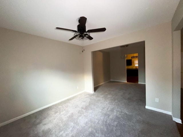 empty room with ceiling fan and dark carpet