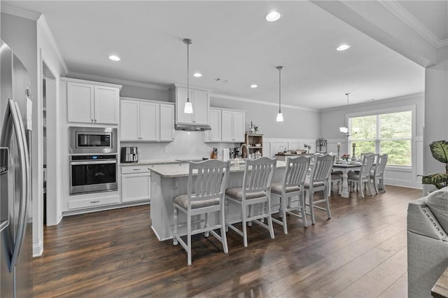 5116 Chastain Way, Gainesville, GA 30507 - kitchen featuring stainless steel appliances, dark wood-style flooring, a breakfast bar area, a kitchen island with sink, and ornamental molding
