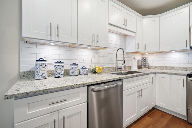 kitchen with tasteful backsplash, dark wood-type flooring, white cabinets, a sink, and dishwasher