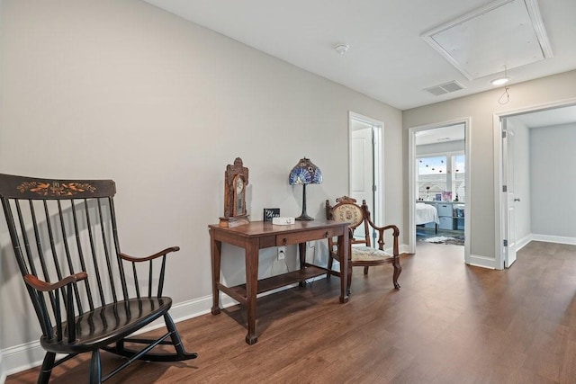 sitting room with baseboards, dark wood-style flooring, visible vents, and attic access