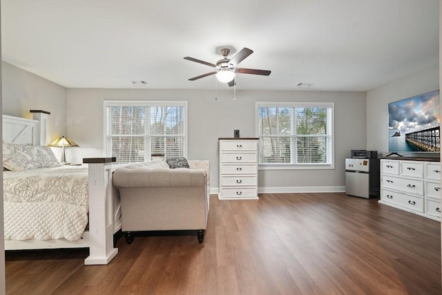 bedroom with dark wood finished floors, visible vents, ceiling fan, baseboards, and fridge