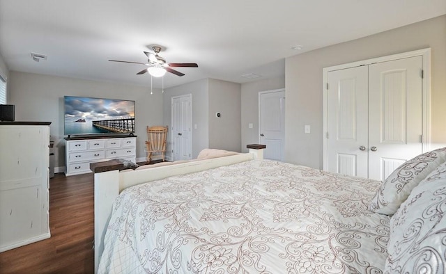 bedroom featuring dark wood-style floors, ceiling fan, a closet, and visible vents