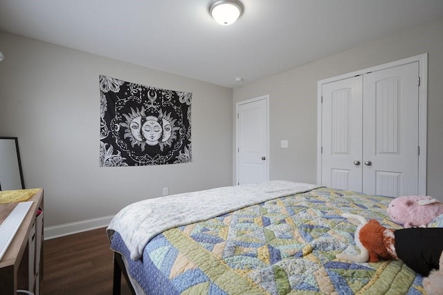 bedroom featuring dark wood-style flooring, a closet, and baseboards